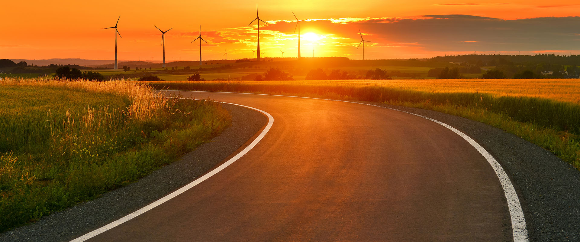 Winding Road With Wind Turbines In The Distance
